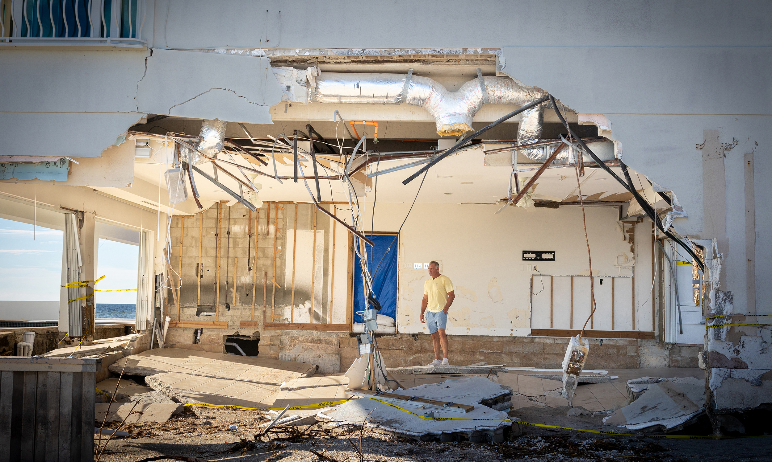 image of man in damaged home after hurricane